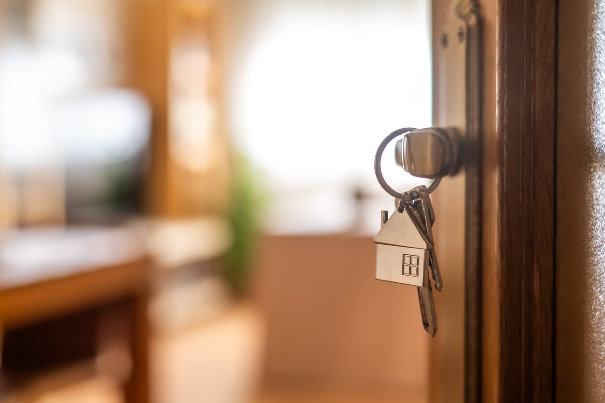 House-shaped keys hanging from the door knob of a new home