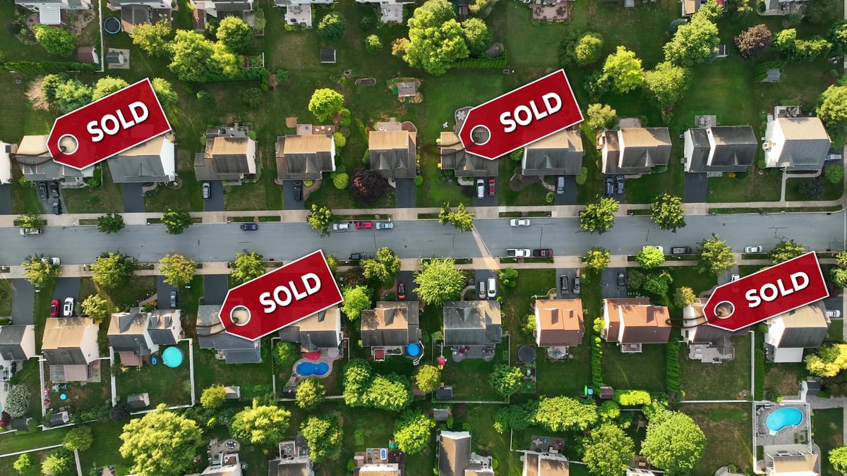 Aerial view of a modern American housing development with sold signs over several homes